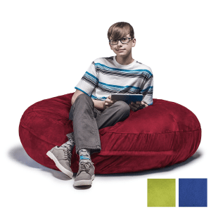 boy sitting on a red cocoon bean bag chair reading a book