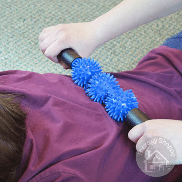 person rolling a spiky sensory rolling pin on a child's back